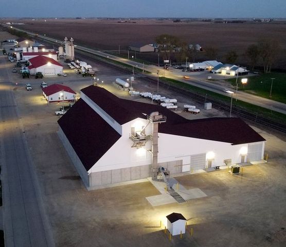 Growmark 9,000 ton dry fertilizer storage and blending plant in Iowa along railroad at sunset