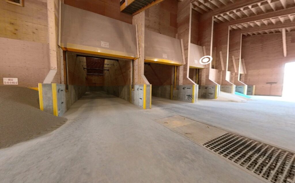Inside view of a dry fertilizer building which features product bins fertilizer pile and blend tower reclaim pit