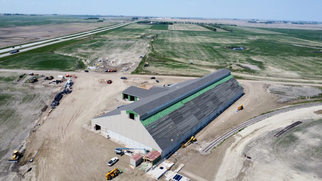 construction site of a dry fertilizer building with roof shingles being added