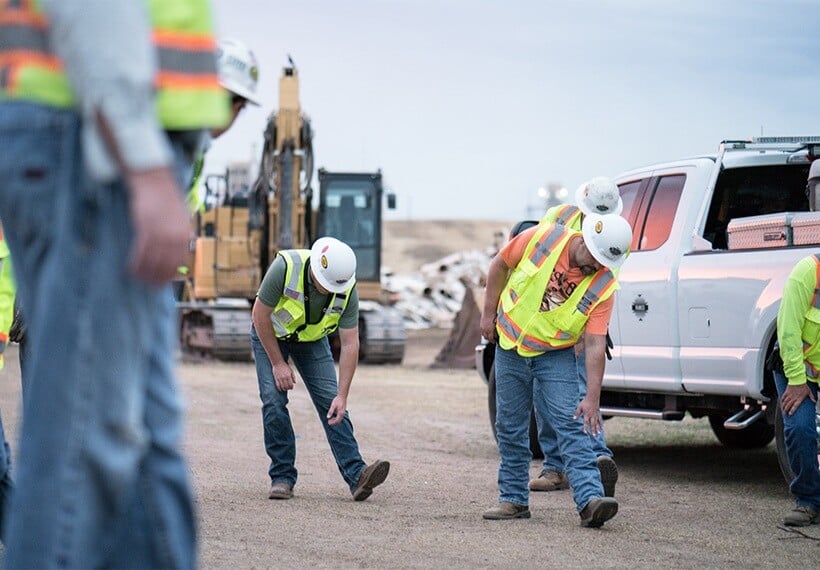 fertilizer storage building construction workers stretching before a long day of building